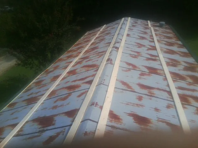 Rusted metal roof panels with new wood purlins before replacement — Storm Damage Roof Repair in Tolono by Roofing Brothers
