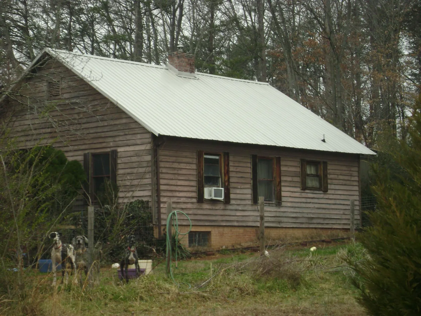 White metal roof on an old wood sided farmhouse, from a Metal Roof Installation job in Tolono